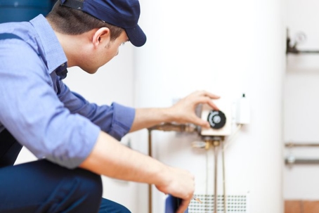 A technician completes the installation on a tankless water heating system.
