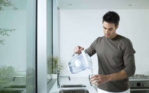 Man pouring water from a filtered pitcher