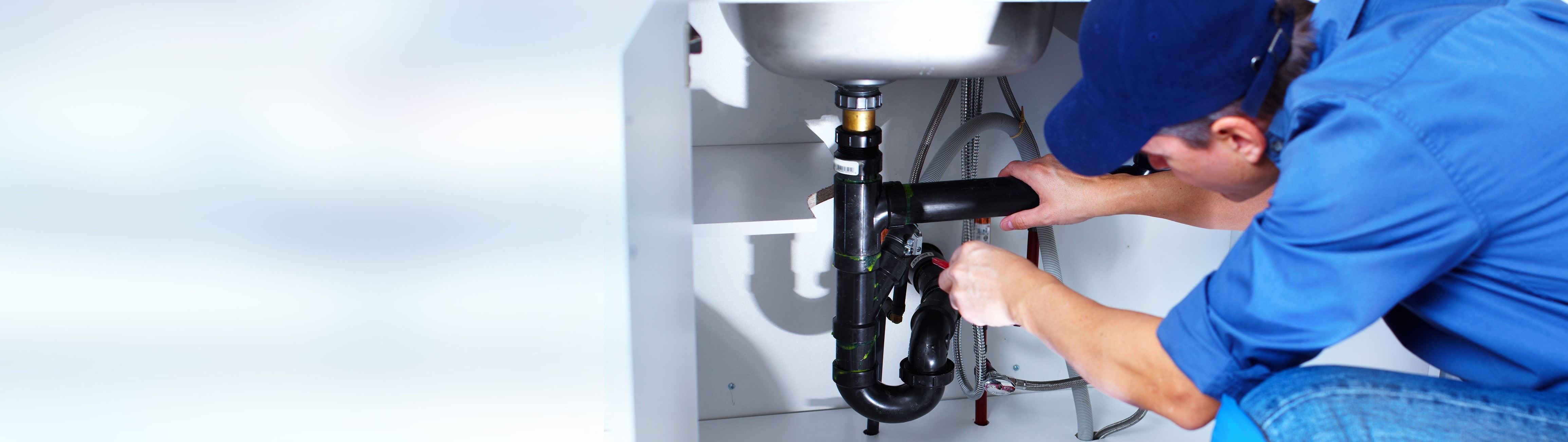 Plumber working under sink